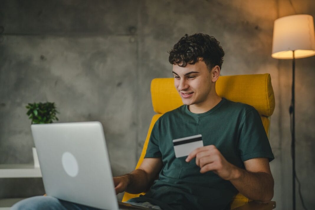 teenager young man at home use credit card shopping online e-banking